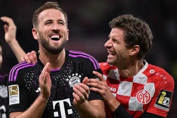 Penyerang Bayern Munich, Harry Kane, memberikan ucapan selamat atas pencapaian rekan setimnya, Thomas Muller, yang baru saja memecahkan rekor penampilan ke-710